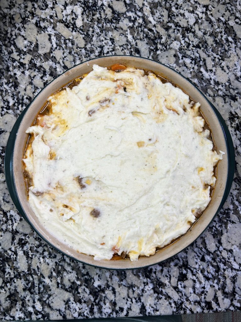 Shepherds pie filling topped with homemade mashed potatoes
