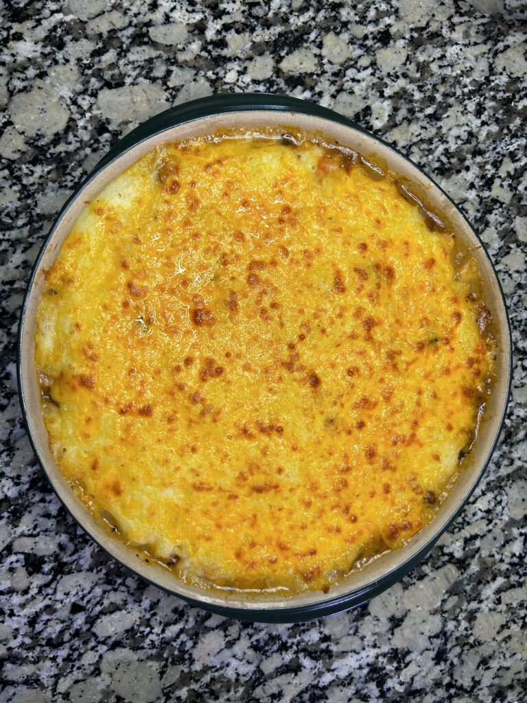 crispy cheese topping baked mashed potatoes on top of a shepherds pie