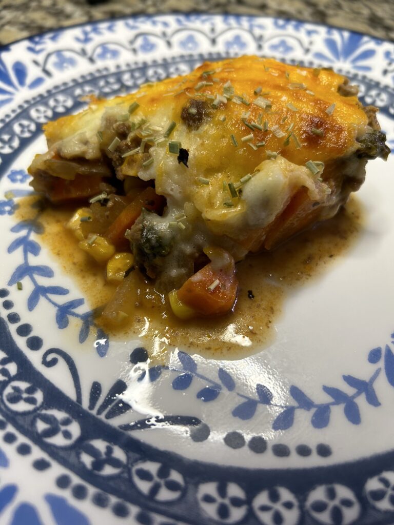 shepherds pie serving on plate topped with dried chives