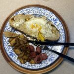 egg in toast with smoked sausage and fried potatoes on plate