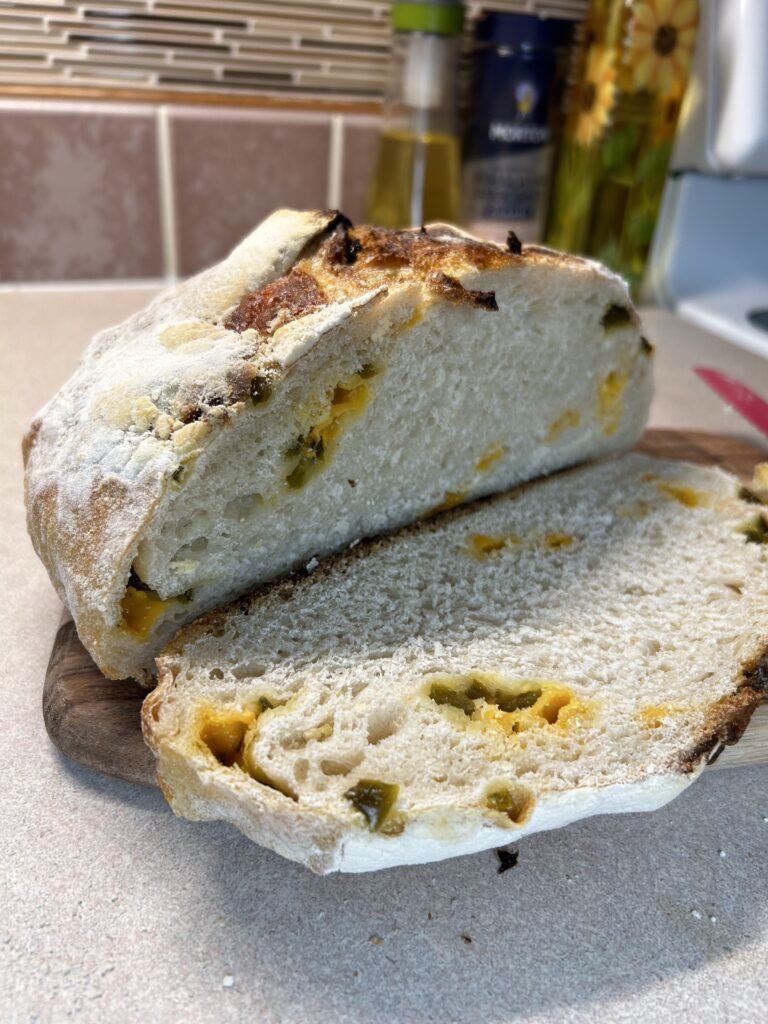 homemade sourdough cheddar jalapeno bread sliced on cutting board