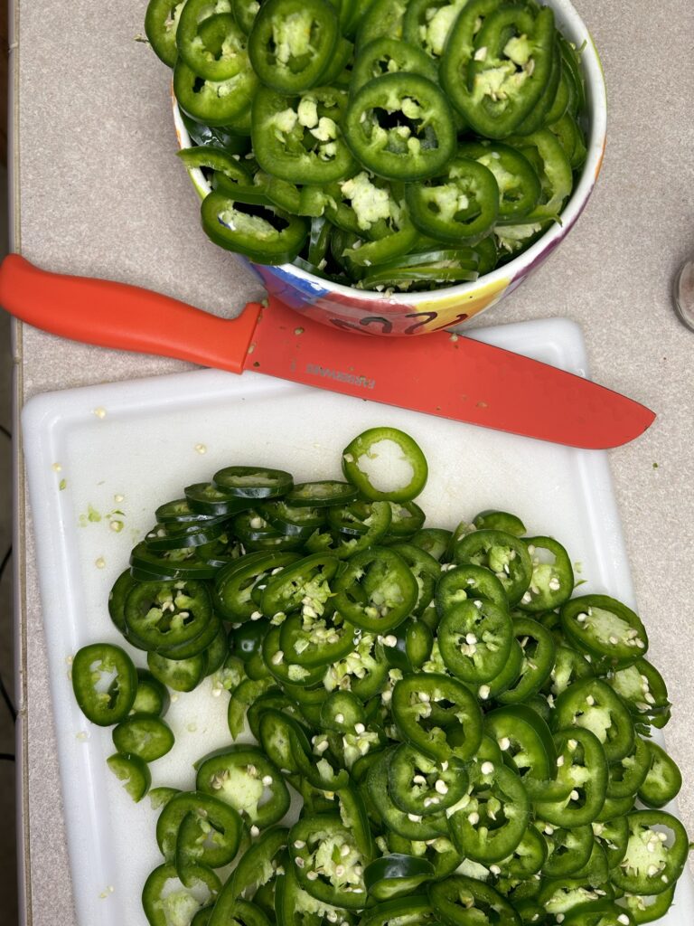 sliced jalapenos on cutting board and in bowl