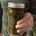 Jar of candied jalapenos held in hand